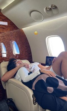 a woman laying on top of an airplane bed