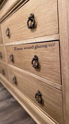 a close up of a wooden dresser with writing on the drawers and knobs that say faux wood glazing oil