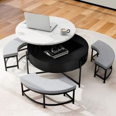 a round table with four stools and a laptop on it in the middle of a room