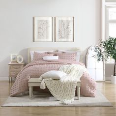 a bedroom with white walls and pink bedding