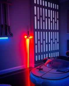 a futuristic car sits in the middle of a room with red, blue and purple lights