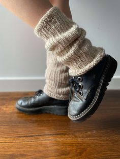 a woman's legs wearing black shoes and socks with knitted leg warmers