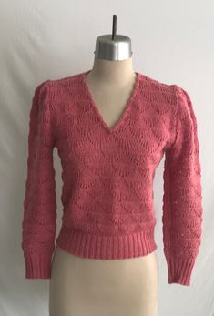 "Sweet 1980's (could be late 1970's) Diane Von Furstenburg rose pink sweater with the most darling puff sleeves, v-neck with shell edging and with an overall feminine boho look to it. The knit pattern are shells creating a textured and lacy look to the fabric. I believe the knit to be machine made, but the edging along the neck would have been hand crafted.  Sweater is clean and in great condition - there's some light pilling here and there.   Label: Diane Von Furstenburg - 100% Acrylic - Machin