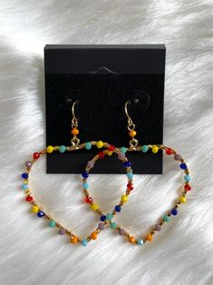 *Cute, colorful seed bead wrapped dangling heart earring *Gold color metal *Bead colors are yellow, red, blue, orange and purple *Very lightweight *Fish-hook style *They are 1.75"X 2" Cheap Rainbow Beaded Dangling Earrings, Orange And Purple Jewerly Beads, Adjustable Beaded Earrings With Heart And Round Beads, Heart-shaped Colorful Beads Jewelry For Beach, Multicolor Jewelry With Heart Charm And Round Beads, Multicolor Heart Charm Dangle Earrings, Multicolor Heart Charm Drop Earrings, Multicolor Wire Wrapped Beaded Earrings, Multicolor Dangle Earrings With Heart Beads