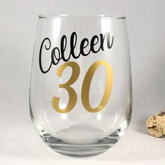 a wine glass with the number 30 on it next to some corks and a bottle opener