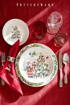 a christmas place setting on a red table cloth