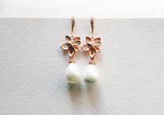 A lovely rose gold pearl earring made with a rose gold floral connector with a pearl drop made with a lovely creamy white shell pearl. This is a beautiful earring that makes a statement with its extremely elegant design. Very versatile, perfect for any special occasion or for a bride or even as a gift for bridesmaid or mother of the bride. Details: Material: rose gold plated brass, cubic zircon Length: approx 1.5 inches Earrings ONLY, Matching necklace available at extra cost. This item is in-st Rose Gold Pearl Drop Flower Earrings, Rose Gold Flower Drop Earrings With Pearl, Feminine Rose Gold Pearl Earrings, Feminine Rose Gold Drop Bridal Earrings, Feminine Rose Gold Pearl Drop Earrings, Delicate Rose Gold Pearl Drop Earrings, Gold Pearl Drop Earrings, Bride Details, Rose Gold Pearl