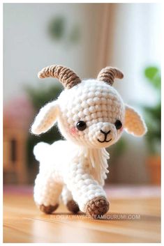 a small crocheted goat with horns on it's head is sitting on the floor