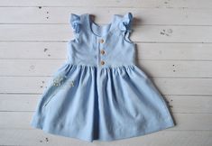 "This listing is for the dress only. Light blue linen dress girl with flutter sleeve and buttons down the back. This dress is made with a medium washed linen. It is perfect for spring or summer but you can alco use it in autumn, with a blouse or a cardigan. It features a round neckline and buttons down the back. The vintage length skirt is finished off with a signature wide hem. Production time: about 3-5 days SIZE GUIDE 6 months, height 28 inches 12 months, height 31,5\" 18 months, height 34\" Cute Linen Beach Dress, Cute Linen Summer Dress, Light Blue Cotton Flutter Sleeve Dress, Light Blue Cotton Dress With Flutter Sleeves, Spring Linen Dress With Ruffle Sleeves, Beige Linen Dress, Blue Baby Dress, White Baby Romper, Linen Pinafore Dress