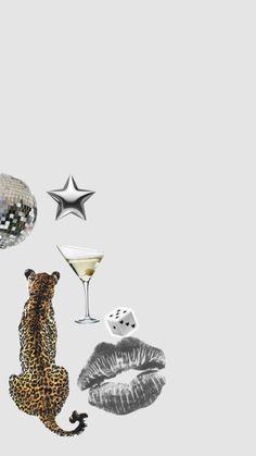 a leopard is sitting on the floor next to a wine glass and some silver balls