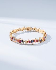 Experience the Bold Burst Rainbow Sapphire Tennis Bracelet, a striking creation that harmoniously blends 7.58 carats of rainbow sapphire baguettes with 2.12 carats of glistening baguette and round G VS diamonds. Each sapphire, cut into sleek baguettes, is set in 18k gold, showcasing a vibrant cascade of colors. Whether gracing a gala or elevating your everyday wardrobe, this tennis bracelet promises to be a treasured addition to your jewelry collection. Details 18k rose gold or yellow gold 7.58 carats of rainbow sapphire baguettes 1.68 carats of baguette white diamonds 0.44 carats of round white diamonds Bracelet measures 7 inches in length Box clasp with safety lock fastening 8.5mm length Ref: AKB366 Colored Tennis Bracelet, Luxury Multicolor Baguette Diamond Jewelry, Sapphire Tennis Bracelet, Diamonds Bracelet, Easy Doodles, Rainbow Sapphires, Doodles Drawings, Vs Diamond, Ruby Sapphire