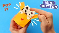 someone is holding an origami cat in front of a blue background with the words pop it