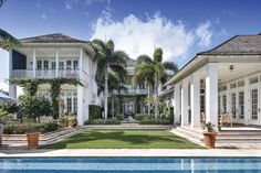 a large white house sitting next to a swimming pool