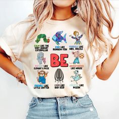 a woman wearing a t - shirt with the words be surrounded by different cartoon characters