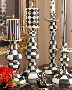 black and white checkered candlesticks on a table in front of a mirror