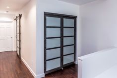 an empty room with white walls and wood flooring is seen in this image from the hallway