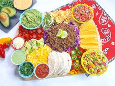 a platter filled with tacos, guacamole and salsa