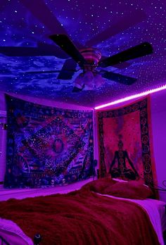 a bed room with a large tapestry on the wall and a ceiling fan hanging from the ceiling