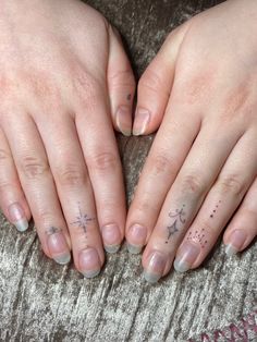 two hands with small tattoos on their fingers