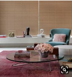 a living room filled with furniture and a window covered in blinds