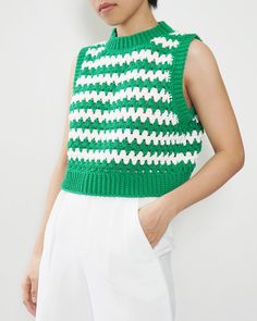 a woman wearing a green and white knitted top