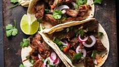 three tacos with meat, onions and cilantro