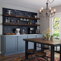 a dining room table and chairs with chalkboard on the wall