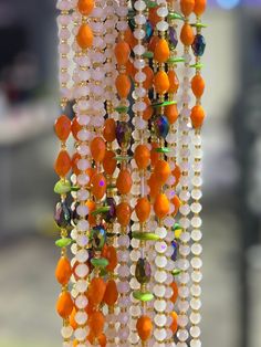 Colors white, green, orange, blue, Gold Features: Austrian crystal beads, Transparent Bar Beads Traditional tie on waist beads Made on 100% African thread Size: approx. 50 inches Priced as individual strand & typically ties once around the waist Orange Faceted Beads, Orange Faceted Oval Beads, Orange Beaded Necklaces With Oval Spacer Beads, Orange Faceted Beads Necklace For Party, Orange Large Beaded Necklaces For Party, Orange Large Beads Necklace For Party, Orange Beaded Necklace With Round Beads For Party, Orange Beaded Necklaces For Party With Round Beads, Orange Large Beaded Necklace For Party