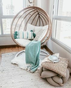 a room with a hanging chair and pillows on the floor