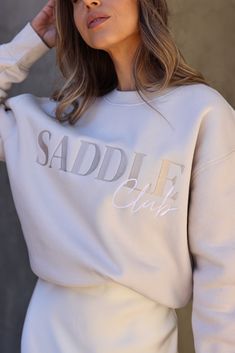 Welcome to the club! Saddle up in style with our Saddle Club Embroidered Sweatshirt. Featuring tone-on-tone lettering embroidered on the front of this crewneck pullover for a subtle but stylish effect. Relaxed fit, mid-weight sweatshirt constructed of a cotton/poly fleece blend. Stylish Equestrian, Saddle Club, Horse Sweater, Equestrian Shirt, Horse Sweatshirts, Horse Fashion, Embroidered Sweatshirt, Sleeve Cuff, Branding Photoshoot