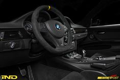 the interior of a car with black leather and yellow trims, including steering wheel