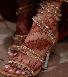 a woman's feet with hennap and gold jewelry