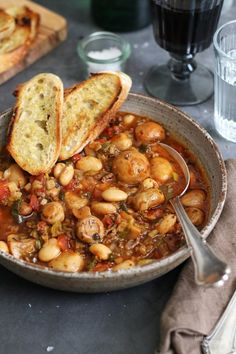 a bowl filled with beans and bread on top of a table