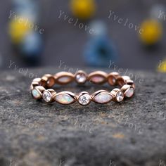 a rose gold ring with white opal stones