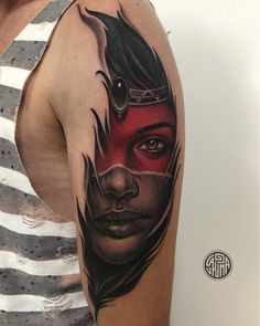 a woman's face with red eyes and black feathers on her head is shown in this tattoo design