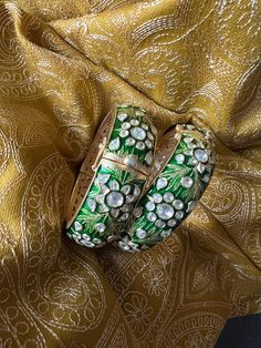 A fine pair of Enamelled Kadas with beautiful design.  Metal Purity: 92.5% Pure Silver Size: 2.25 inches Inner Diameter. Openable, Extra Support Clip. Recommended for wrist sizes of 2.4 Set of Two (2) The weight of the Kadas is 178 grams for the pair. Luxury Green Meenakari Jewelry, Designer Engraved Jewelry For Wedding, Designer Handmade Wedding Jewelry, Designer Meenakari Jewelry For Formal Occasions, Green Meenakari Jewelry For Formal Occasions, Elegant Green Meenakari Bangle, Designer Green Jewelry For Formal Occasions, Formal Green Meenakari Jewelry, Luxury Meenakari Bracelets