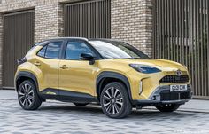 a yellow toyota suv parked in front of a brick building