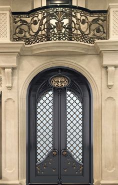 an ornate iron door with glass panels and wrought iron work on the top part of it