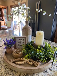 a tray with flowers and candles on top of a kitchen counter