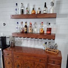 there are many bottles and glasses on the bar