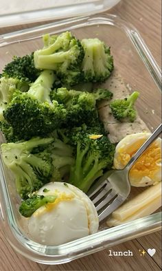 a plastic container filled with broccoli and an hard boiled egg next to a fork