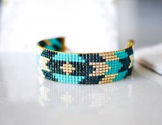 Woven bracelet with turquoise blue and gold miyuki beads, handmade. This bracelet is made with high quality materials and will last over time. Made from noble regular glass beads, it will seduce every woman with its beauty and shine. I make these jewelry in my free time, it gives me a lot of pleasure. I hope they delight you just as much. * Length: 21 cm * Width: 1.6 cm * Color: Midnight blue, blue and gold * Miyuki beads - 24K gold plated glass beads * Stainless steel tube ends gilded with 16K Bead Woven Bracelet, My Free Time, Customizable Jewelry, Woven Bracelet, Small Gift Boxes, Bleu Turquoise, Woven Bracelets, Miyuki Beads, Beads Handmade