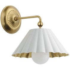 an antique brass wall light with a white glass shade on the arm and gold metal fittings