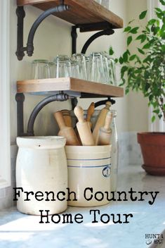 a kitchen counter with jars and utensils on the shelf next to a potted plant