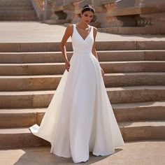 a woman in a white dress standing on some steps