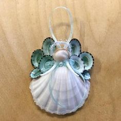 an ornament shaped like a shell with sea shells and pearls on the side