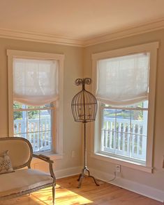 a living room with two windows and a birdcage