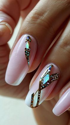 a woman's hand with pink and gold nail polishes on her nails, decorated with jewels