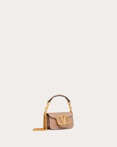 Valentino Garavani Locò micro bag in calfskin leather with chain and VLogo Signature metallic element. Equipped with both a detachable sliding chain strap and a detachable handle, this accessory can be worn as a crossbody/shoulder bag or carried as a handbag. - Antique-brass finish hardware - Magnetic closure - Removable leather handle - Shoulder strap with removable sliding chain - Nappa leather lining. Interior: one card slot Shoulder strap drop length: 55 cm / 21.6 in. - Handle drop length: 7 Valentino Nude Bag, Designer Top Handle Bag With Chain, Micro Bag, Women Rising, Valentino Bags, Nappa Leather, Brass Finish, Magnetic Closure, Leather Handle