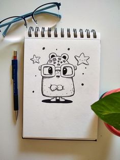 a notebook with a cartoon character drawn on it next to a pen and eyeglasses